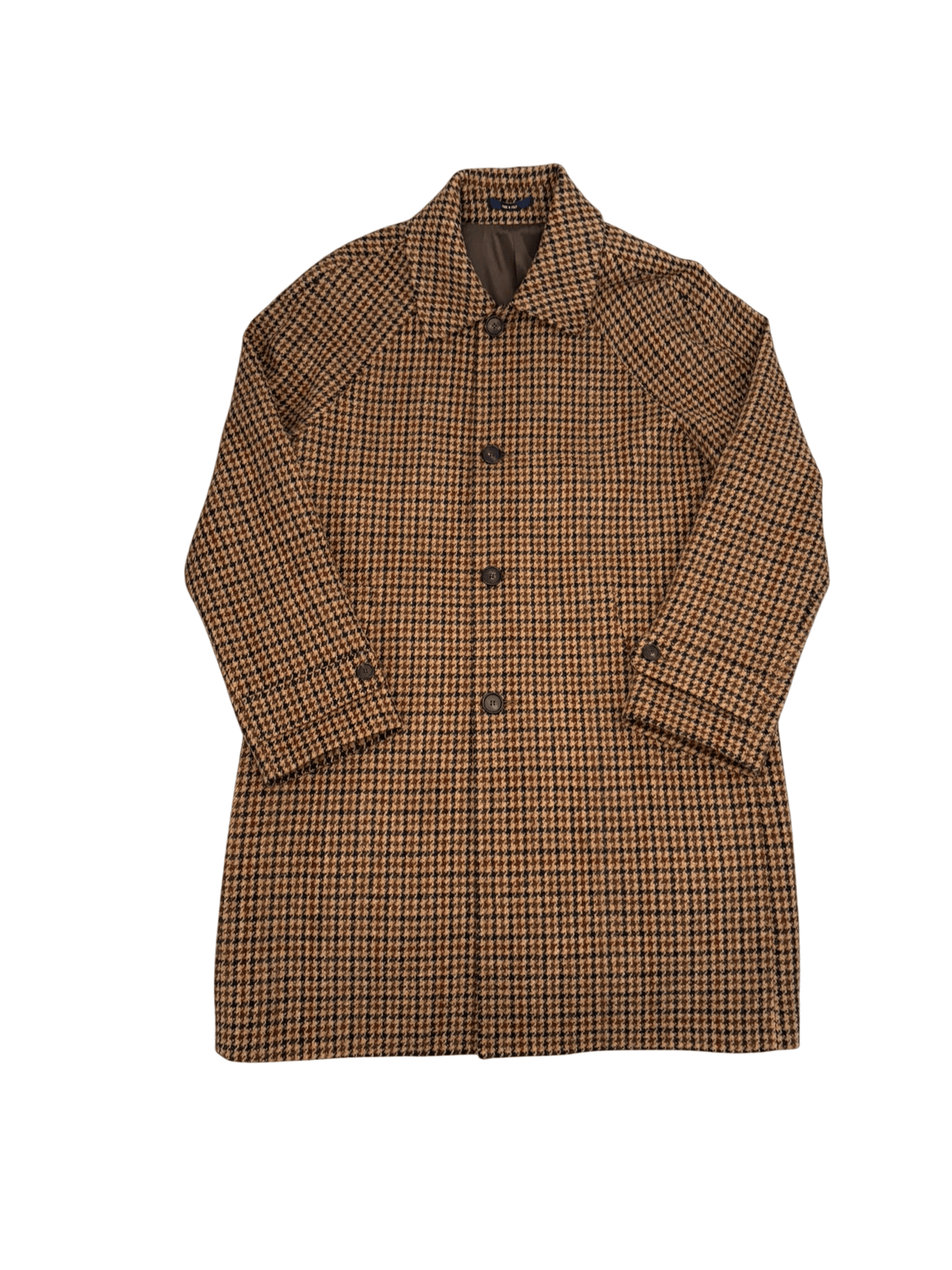 Campbell’s of Beauly The Inverness Coat is a knee-length Harris Tweed overcoat in a brown and black dogtooth pattern with a pointed collar, front button closure, and button-tab cuffs.