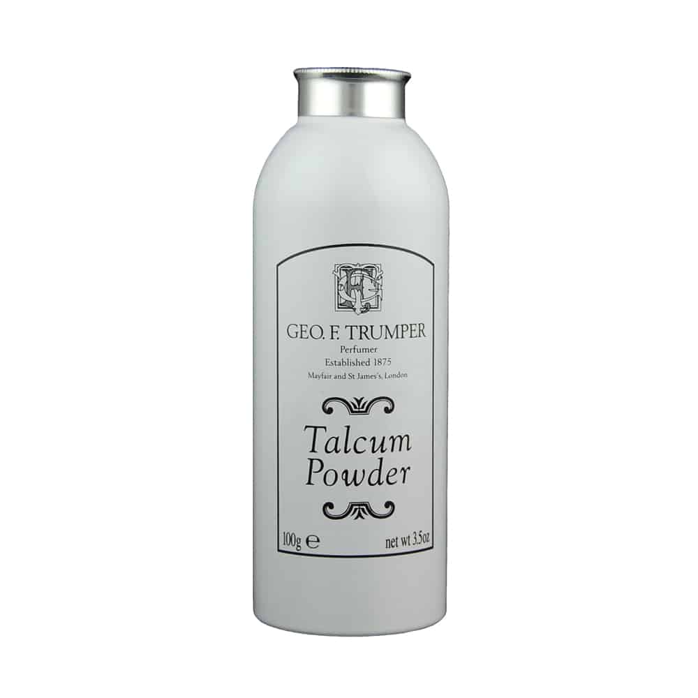 A white bottle of Geo. F. Trumper Talcum Powder with a silver cap, featuring the brand’s black logo and text on the front, stating “Perfumer Established 1875” and “100g e / net wt. 3.5oz.”.