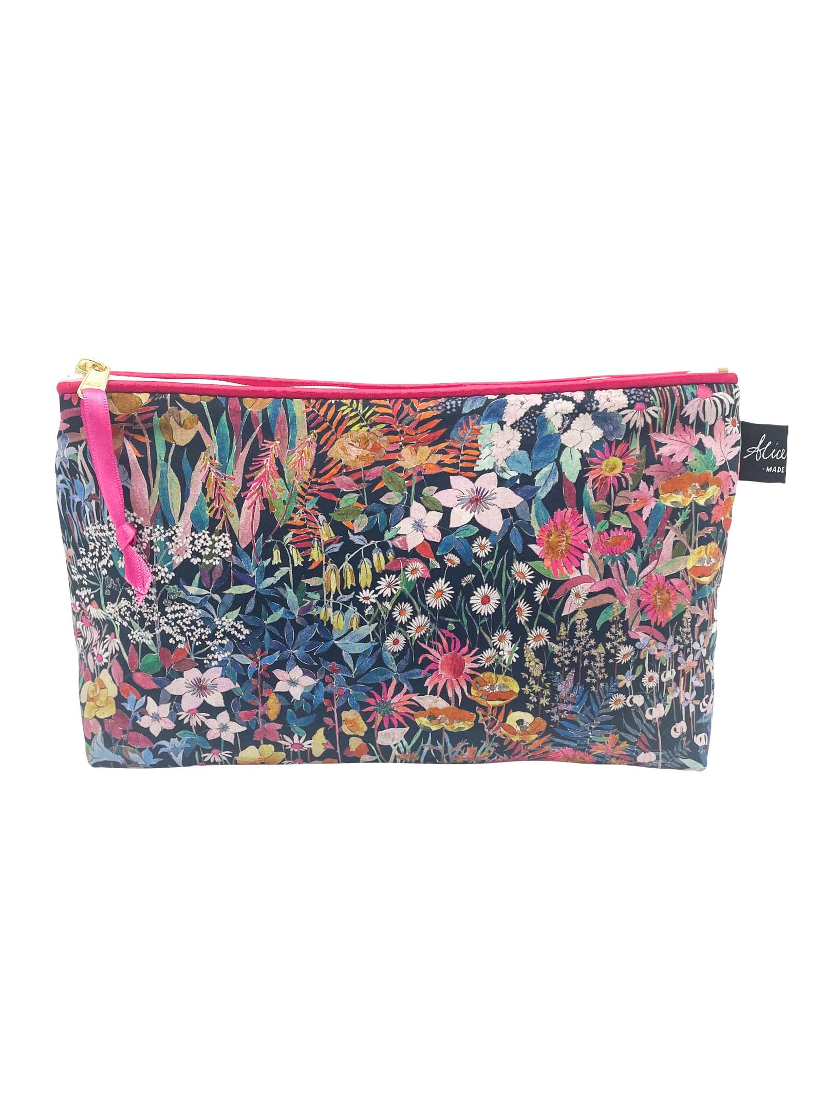 The Alice Caroline Liberty Print Cosmetic Bag in Faria features a colorful floral design with a pink zipper and side tag, crafted from signature Liberty prints.