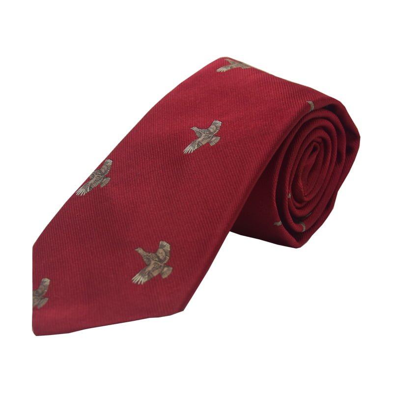 The Campbells of Beauly Full Flight Grouse Silk Tie is an 8cm-wide rolled red tie featuring a repeating countryside motif of detailed brown and gray birds in flight, shown against a plain white background.