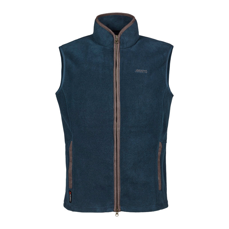 The Musto Fenland Polartec® Vest is a sleeveless navy blue fleece with a high collar, full front zip, two vertical zip pockets, and brown trim. The Musto logo is subtly embroidered on the left chest—an ideal layering essential.