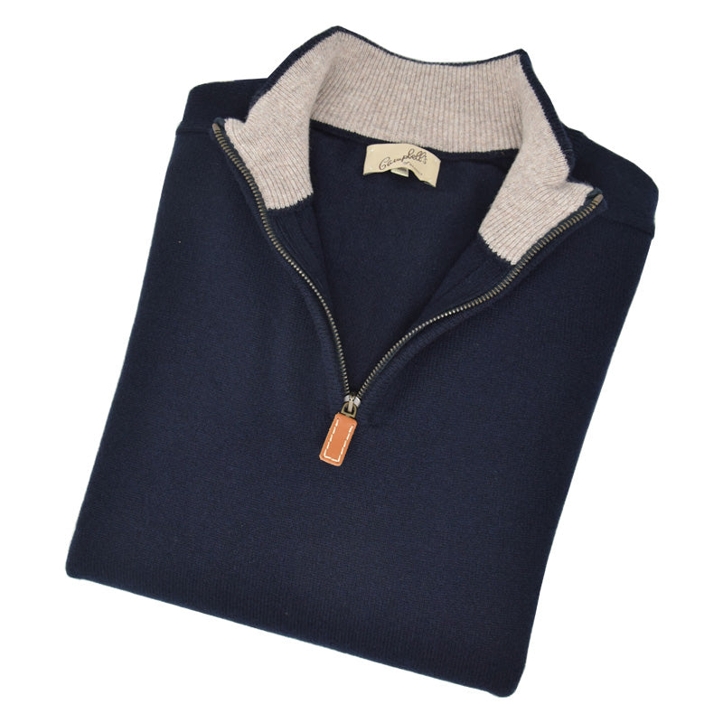 A neatly folded navy Lambswool Quarter Zip Jumper by Campbells of Beauly, featuring a tan zipper pull, open collar with contrasting beige ribbed lining, visible brand label, and crafted from soft lambswool inspired by the Scottish Borders.