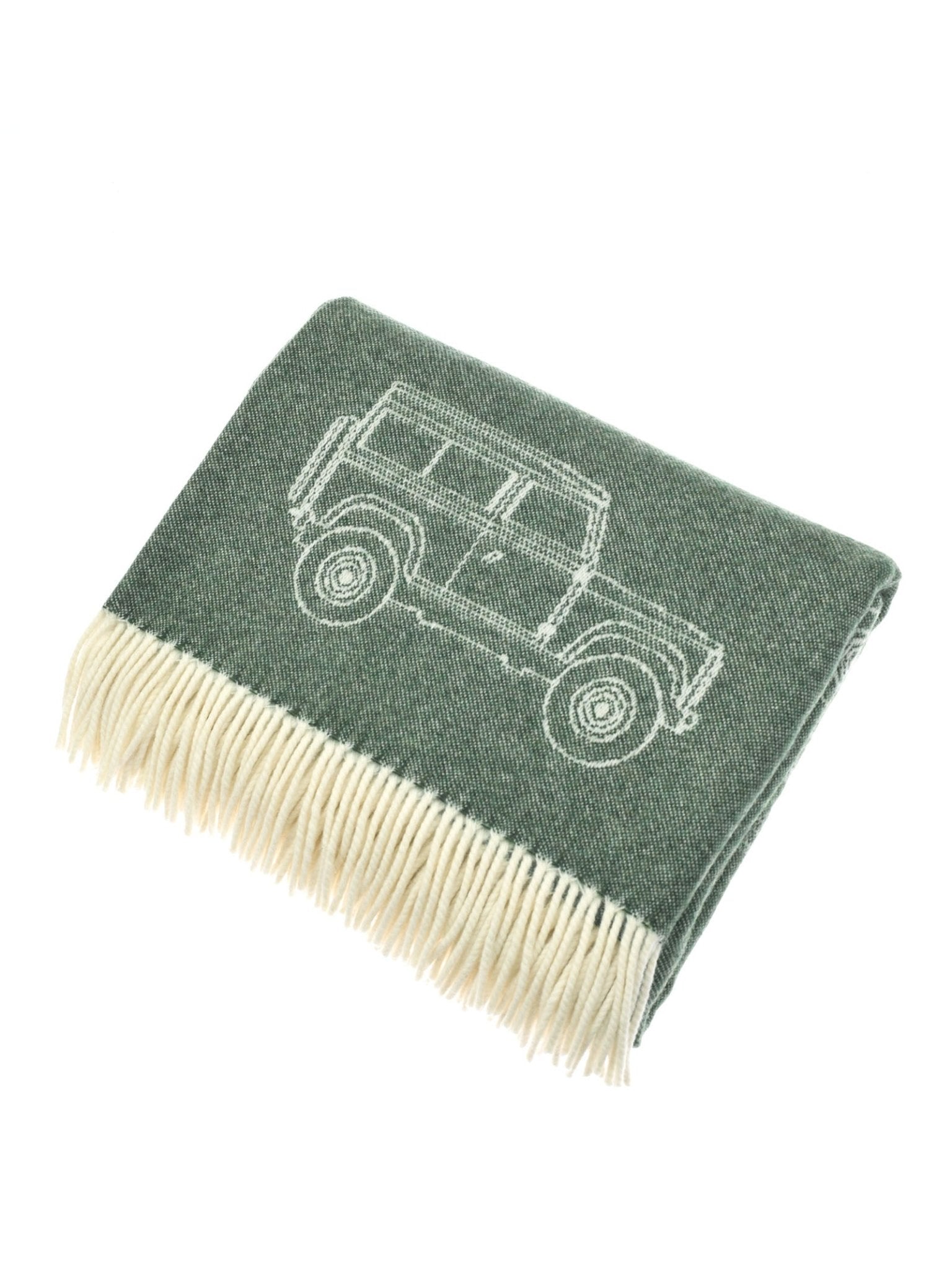 The Campbell's of Beauly Land Rover Defender Jacquard Throw is a folded green British wool blanket with a cream fringe and an outline drawing of a Land Rover Defender.
