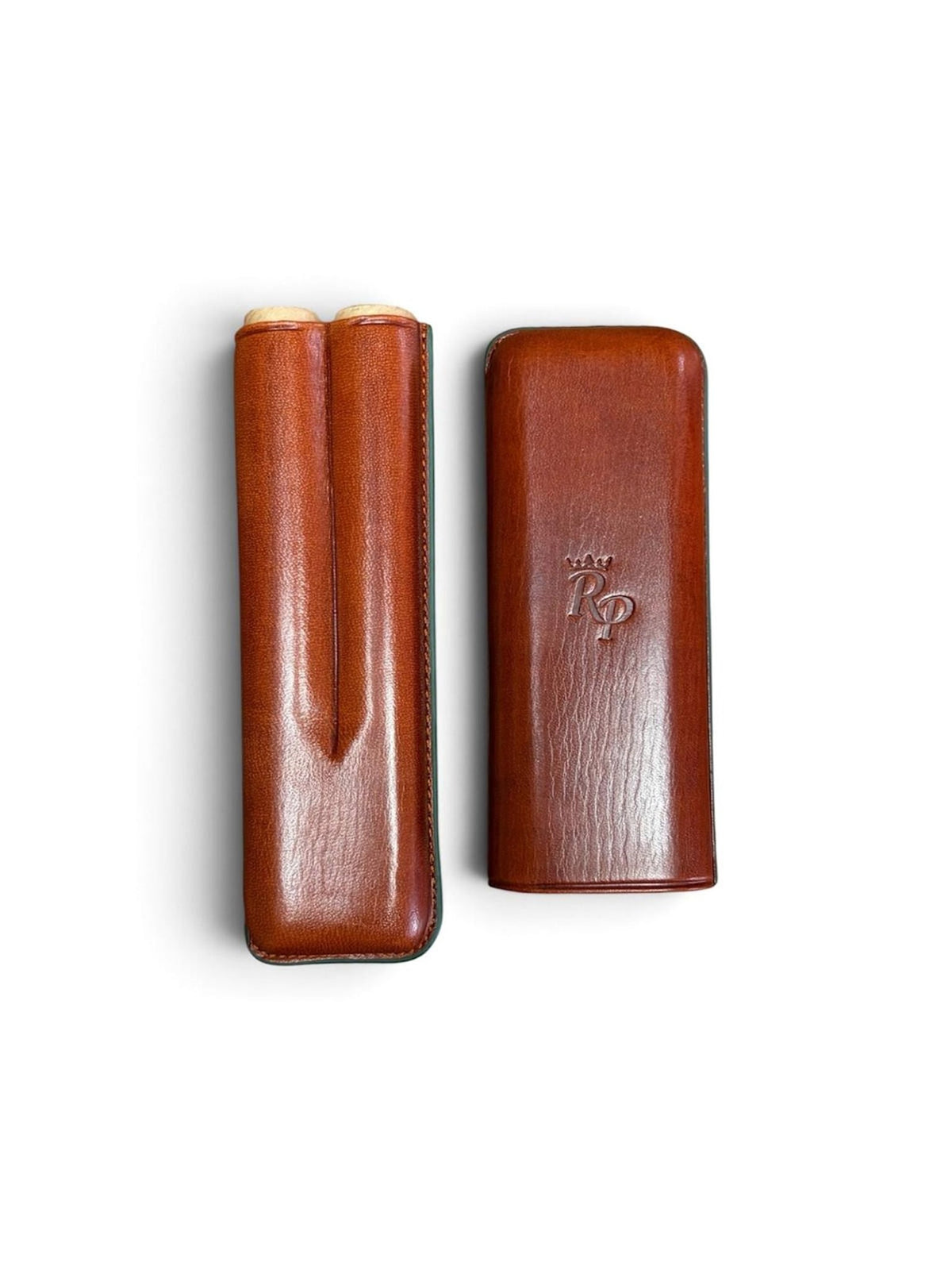 Two brown Leather Cigar Cases from Rey Pavón—one open to reveal two cigars inside the classic tubular design, and the other closed with “RP” embossed on the front.