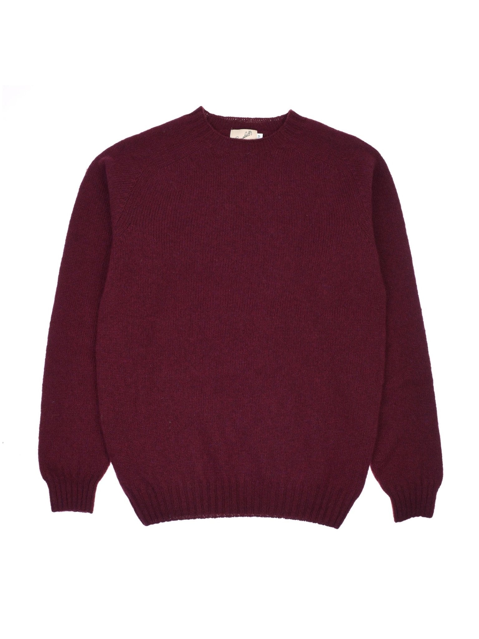 The Campbell's of Beauly Shetland Jumper in Bordeaux is a plain, long-sleeved wool sweater with a crew neck and ribbed cuffs, hem, and neckline, shown laid flat on a white background.